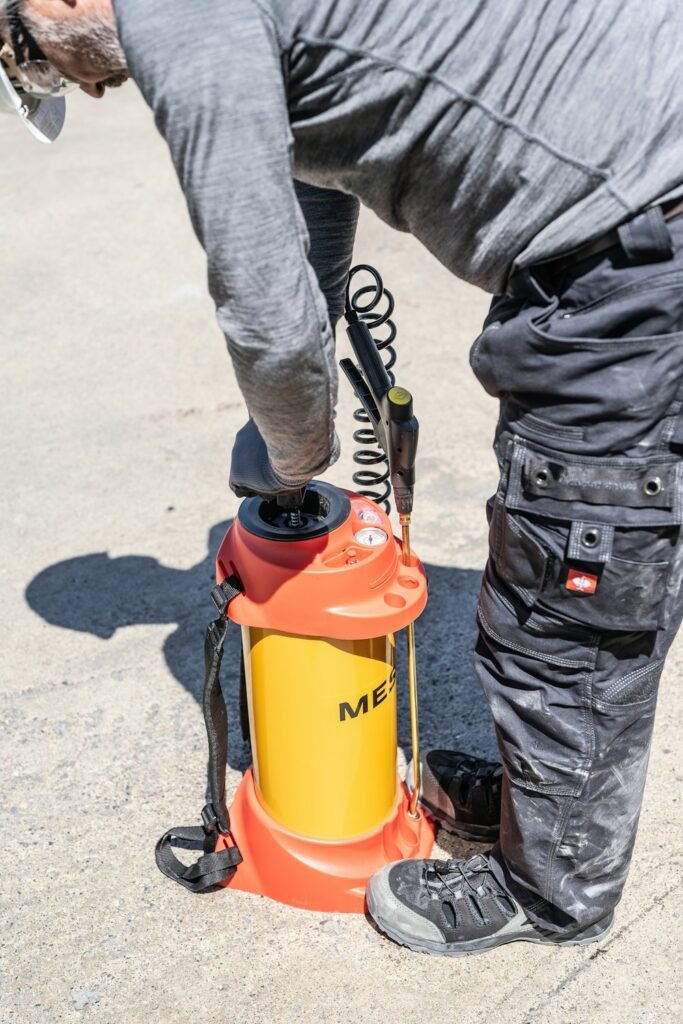 Exterminator preparing a pressure sprayer